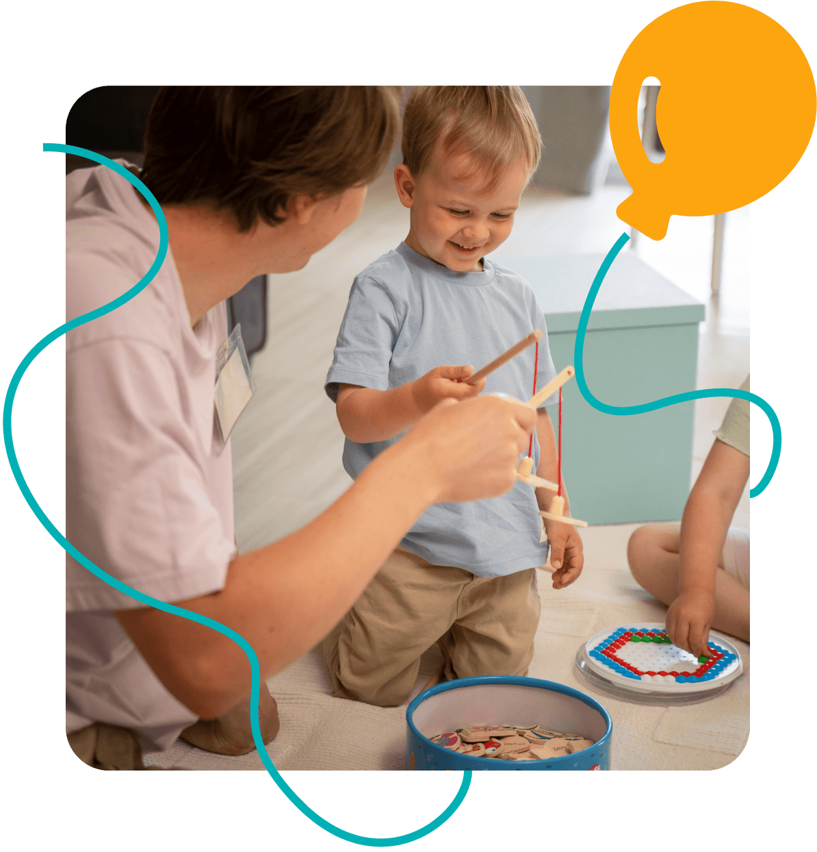 A person shows a wooden toy to a smiling child